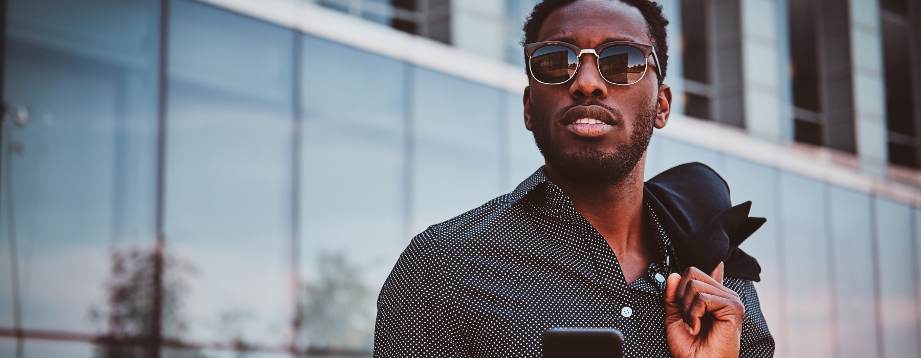 Man texts on his phone as he walks through
