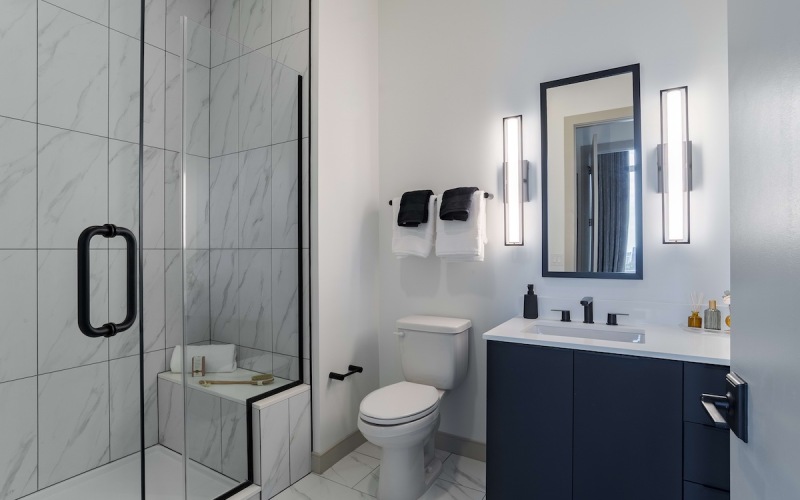 white marble bathroom with sink toilet and shower