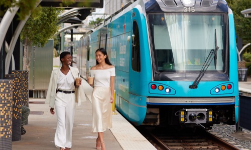 two women standing next to train